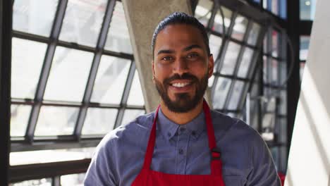 Portrait-of-mixed-race-male-cafe-owner-looking-at-the-camera-and-smiling