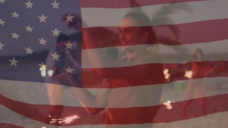 Animation-Einer-Amerikanischen-Flagge,-Die-über-Einer-Gruppe-Von-Freunden-Weht,-Die-Wunderkerzen-Am-Strand-Halten