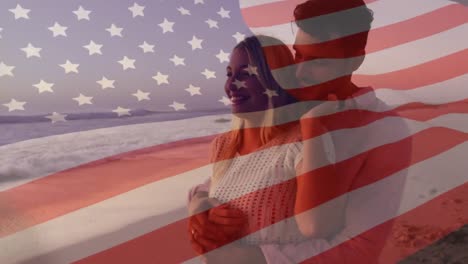 Animation-of-american-flag-waving-over-couple-in-love-embracing-on-beach