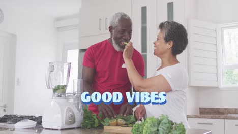Good-vibes-text-against-african-american-woman-feeding-chopped-fruits-to-her-husband-at-home