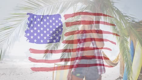 Bandera-Americana-Ondeando-Contra-Una-Mujer-Caucásica-Disfrutando-De-La-Vista-De-La-Playa