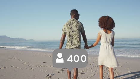 Profilsymbole-Mit-Zunehmender-Zahl-Gegen-Ein-Afroamerikanisches-Paar,-Das-Am-Strand-Spaziert