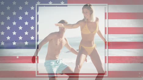 Animation-of-american-flag-waving-over-man-and-woman-learning-to-surf-on-beach