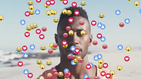 Mehrere-Digitale-Symbole-Schweben-Vor-Dem-Porträt-Eines-Afroamerikanischen-Mannes,-Der-Am-Strand-Lächelt