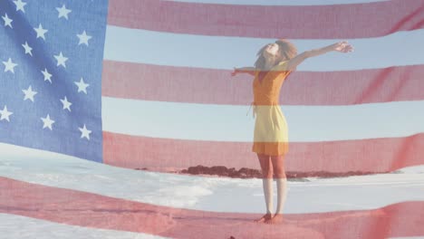 Bandera-Americana-Ondeando-Contra-Una-Mujer-Afroamericana-De-Pie-Con-Los-Brazos-Abiertos-En-La-Playa