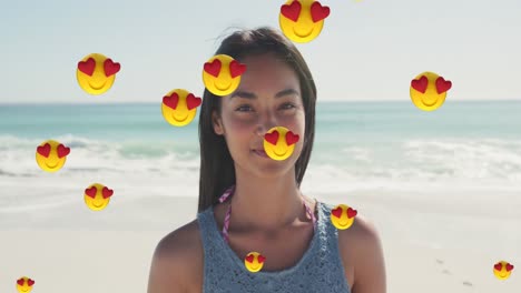 Múltiples-Emojis-De-Ojos-De-Corazón-Flotando-Contra-Una-Mujer-Caucásica-Sonriendo-En-La-Playa
