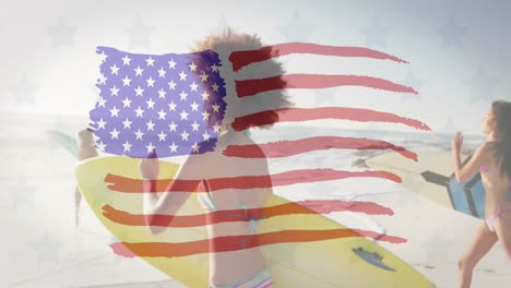 Estrellas-Y-Bandera-Americana-Ondeando-Contra-Un-Grupo-De-Amigos-Con-Tablas-De-Surf-Corriendo-En-La-Playa.