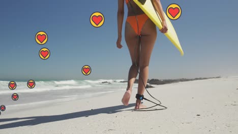 Animation-of-heart-digital-icons-over-woman-carrying-surfboard-on-beach