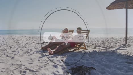 Animation-of-speech-bubble-with-likes-text-and-numbers-over-couple-in-deckchairs-on-beach