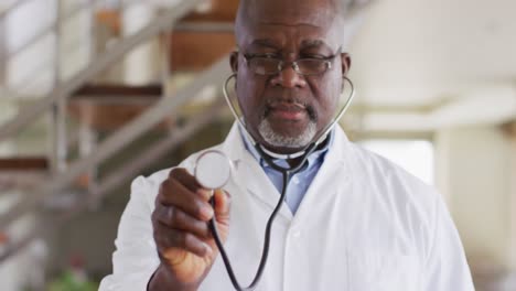 Médico-Masculino-Senior-Afroamericano-Usando-Un-Estetoscopio-En-Casa