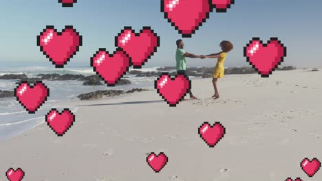 Animation-of-heart-digital-icons-over-couple-dancing-on-beach