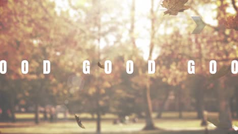 Animation-of-the-words-good-vibes-in-black-and-white-over-sunlit-autumn-trees