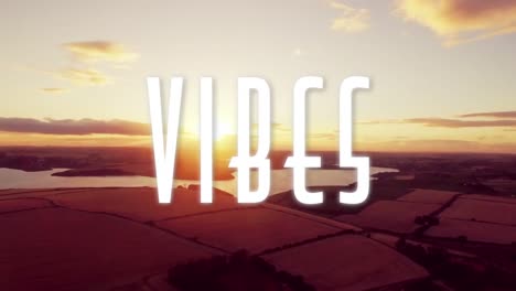 Animation-of-the-word-vibes-written-in-white-letters-with-sun-setting-over-lakes-and-countryside