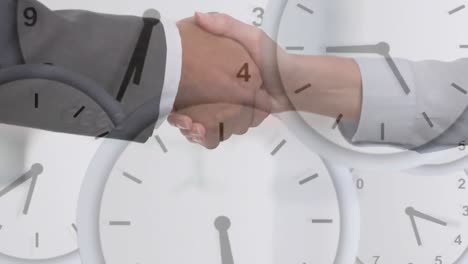 Animation-of-clocks-moving-fast-over-businessman-and-businesswoman-shaking-hands