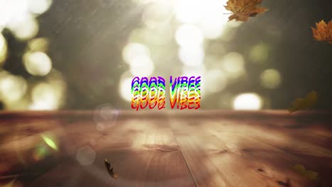 Animation-of-the-words-good-vibes-in-rainbow-letters-over-falling-autumn-leaves-and-bokeh-sunlight