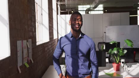 Portrait-of-smartly-dressed-african-american-businessman-at-office-looking-to-camera-smiling