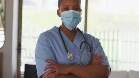 Portrait-of-african-american-female-doctor-wearing-mask-looking-to-camera