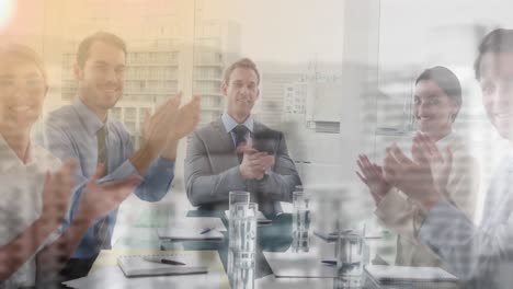 Animation-of-business-people-smiling-and-clapping-in-office-over-cityscape