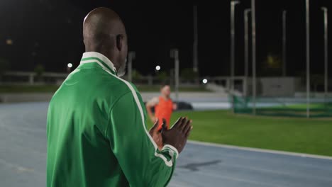 Afroamerikanischer-Männlicher-Trainer-Klatscht-Und-Beobachtet-Behinderten-Männlichen-Athleten-Beim-Laufklingentraining