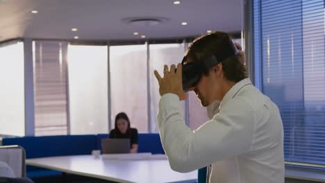 Data-processing-and-scope-scanning-over-caucasian-man-wearing-vr-headset-at-office
