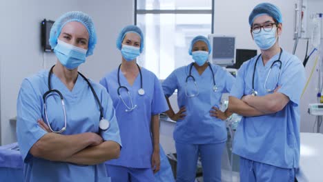 Portrait-of-diverse-female-and-male-surgeons-wearing-face-masks-and-scrubs-in-hospital