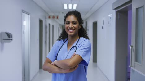 Portrait-of-smiling-asian-female-doctor-wearing-scrubs-standing-in-hospital-corridor
