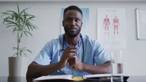 Afroamerikanischer-Männlicher-Arzt-Am-Schreibtisch,-Der-Während-Der-Videoanrufberatung-Spricht-Und-Gestikuliert