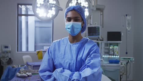 Portrait-of-asian-female-surgeon-wearing-face-mask-standing-in-hospital-operating-theatre