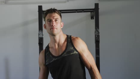 Fit-smiling-caucasian-man-turning-to-camera-inside-gym