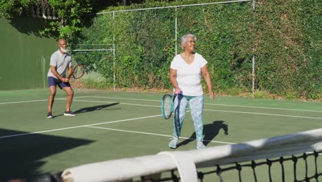 Afroamerikanisches-älteres-Paar,-Das-An-Einem-Strahlend-Sonnigen-Tag-Tennis-Auf-Dem-Tennisplatz-Spielt