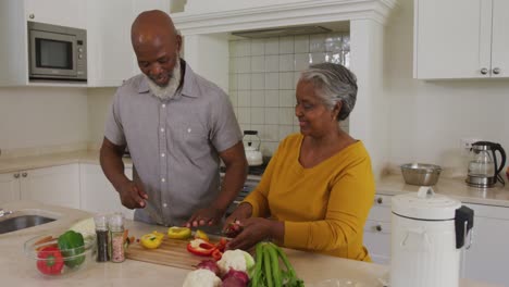 Afroamerikanisches-Seniorenpaar,-Das-Zu-Hause-In-Der-Küche-Gemeinsam-Gemüse-Hackt