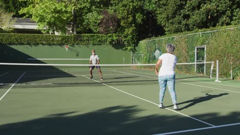 Afroamerikanisches-älteres-Paar,-Das-An-Einem-Strahlend-Sonnigen-Tag-Tennis-Auf-Dem-Tennisplatz-Spielt