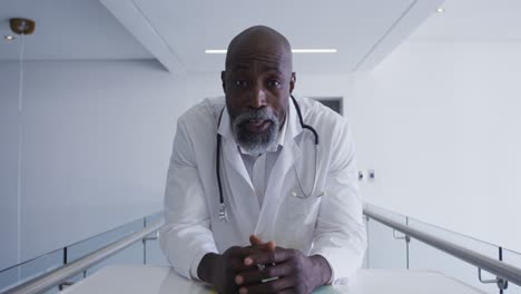 Porträt-Eines-Afroamerikanischen-Männlichen-Oberarztes,-Der-Im-Krankenhaus-In-Die-Kamera-Blickt