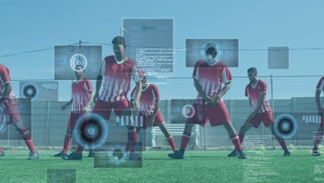 Animation-of-scopes-and-data-processing-on-screens-over-male-football-players-warming-up