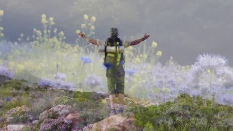 Happy-caucasian-senior-man-hiking-in-countryside-over-wild-flowers-moving-in-the-wind
