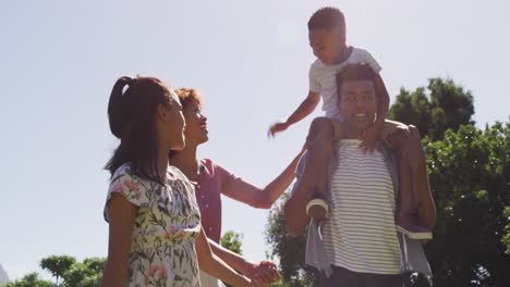 Felices-Padres-Afroamericanos,-Hija-E-Hijo-Caminando-Al-Aire-Libre