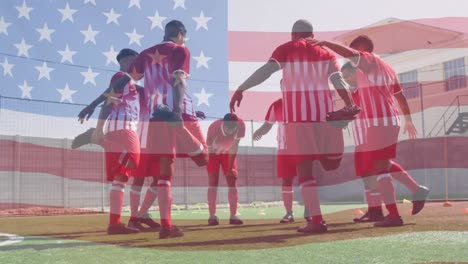Animation-of-american-flag-waving-over-team-of-male-football-players-warming-up-before-match