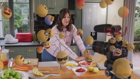 Animation-Von-Emoji-Symbolen-über-Einer-Kulinarischen-Vloggerin,-Die-Zu-Hause-Einen-Vlog-Aufzeichnet