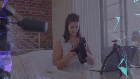 Animation-of-network-of-connections-over-female-vlogger-holding-camera-recording-vlog-at-home