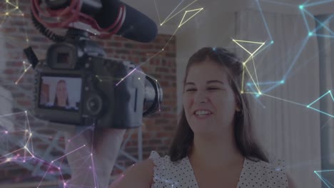 Animation-Eines-Netzwerks-Von-Verbindungen-über-Die-Kamera-Mit-Einer-Vloggerin,-Die-Zu-Hause-Einen-Vlog-Aufzeichnet