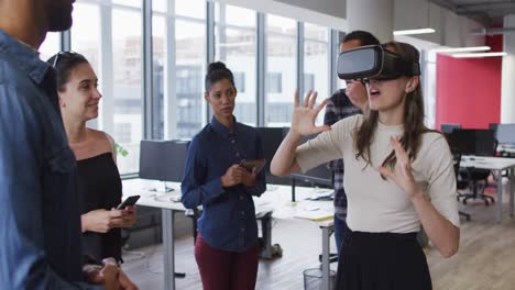 Diverse-group-of-business-colleagues-using-vr-headset-during-meeting