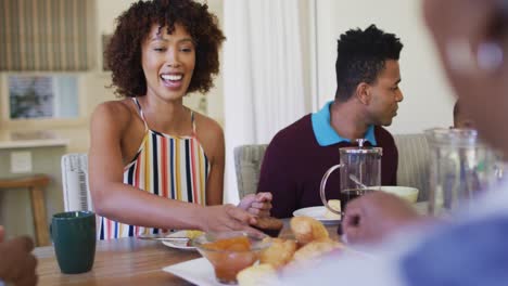 Afroamerikanische-Frau-Gibt-Ihrer-Mutter-Cupcake,-Während-Sie-Zu-Hause-Gemeinsam-Frühstückt