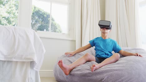 Kaukasischer-Junge-Trägt-VR-Headset,-Während-Er-Zu-Hause-Auf-Dem-Sitzsack-Sitzt