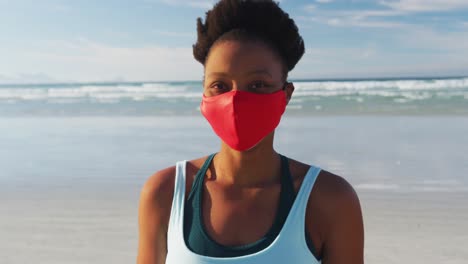 Portrait-of-african-american-woman-wearing-face-mask-at-the-beach