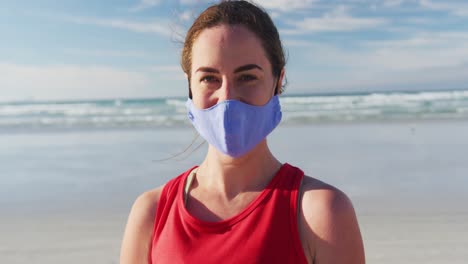 Portrait-of-caucasian-woman-wearing-face-mask-at-the-beach