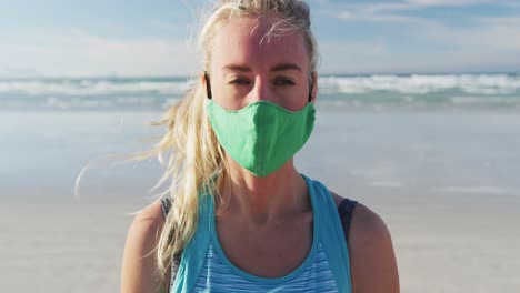 Portrait-of-caucasian-woman-wearing-face-mask-at-the-beach