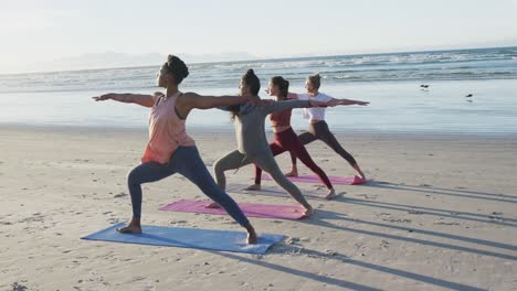 Gruppe-Verschiedener-Freundinnen,-Die-Yoga-Am-Strand-Praktizieren