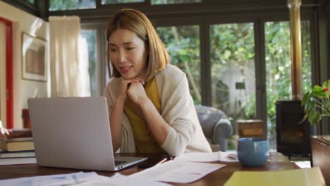 Asiatische-Frau-Sitzt-Am-Tisch-Und-Arbeitet-Von-Zu-Hause-Aus-Und-Benutzt-Einen-Laptop