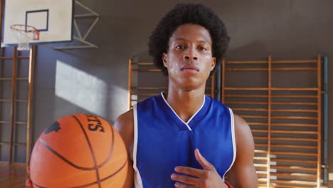 Porträt-Eines-Afroamerikanischen-Männlichen-Basketballspielers,-Der-Den-Ball-Hält