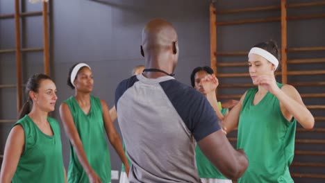 Diverses-Weibliches-Basketballteam-Beim-Stretching-Mit-Männlichem-Trainer